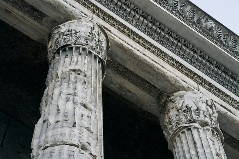 two tall columns with floral decoration are near a building