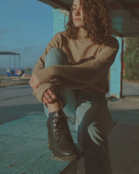 a woman sits on a wooden bench looking at the sky