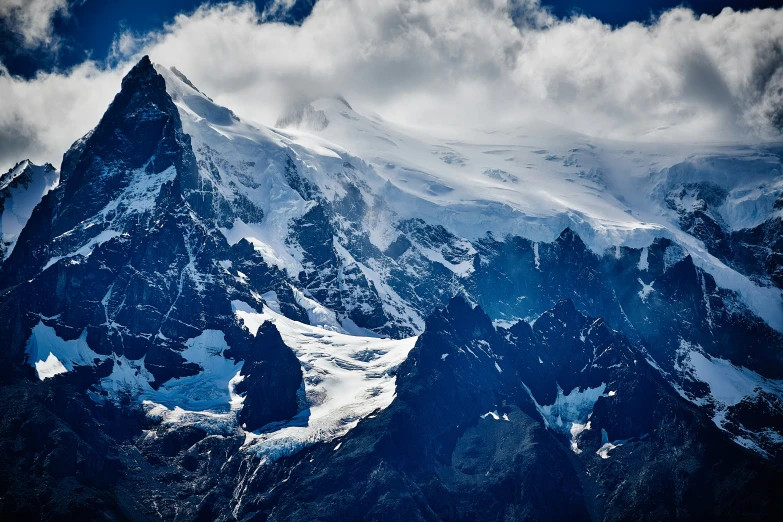 a snowy mountain with a small patch of snow under it