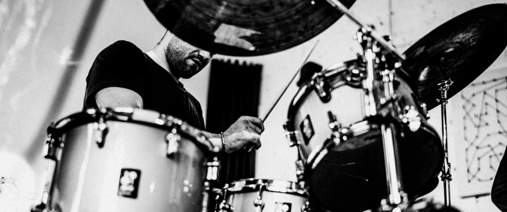 a man playing a drum set in black and white