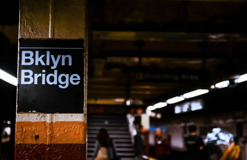 a black and orange sign that says brooklyn bridge