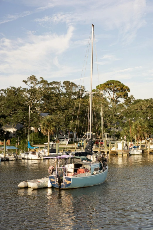 a sailboat traveling on the river and surrounded by boats