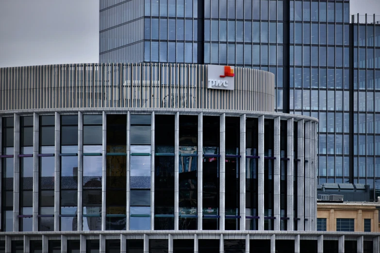 a modern building with glass panels and a large clock on it