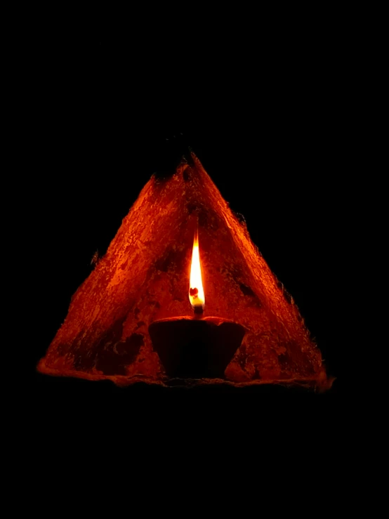 a lit candle sitting inside of a piece of wood