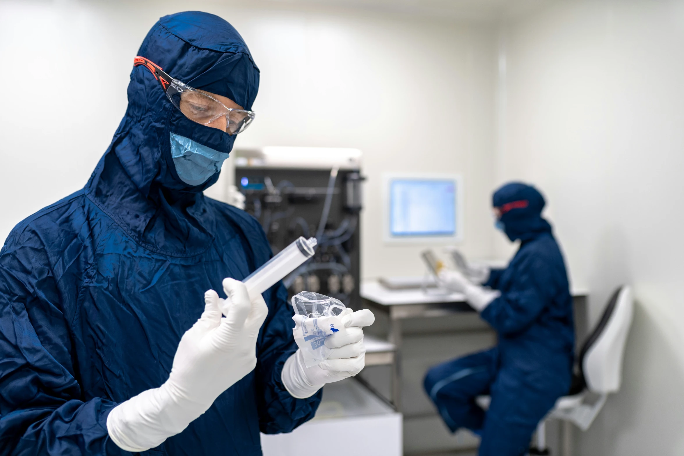 a man in a dark blue coverall holding a cell phone