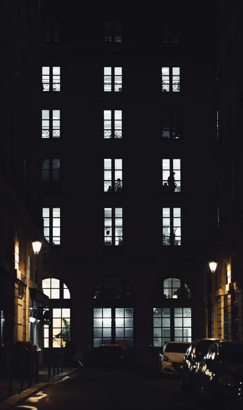 three cars parked outside of some windows at night