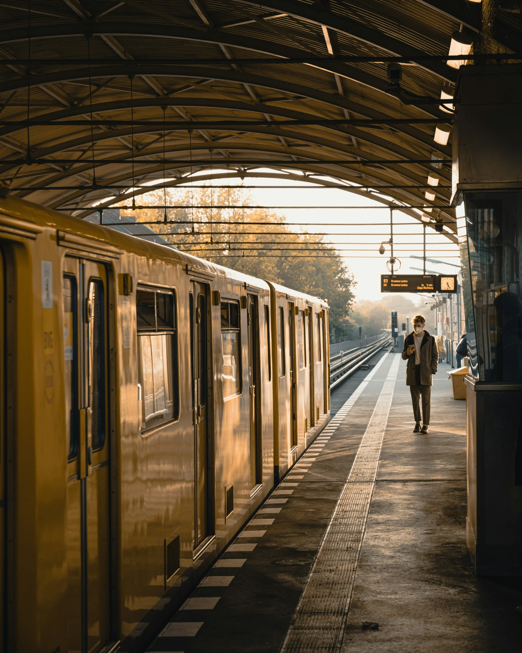 there is a man that is walking along the train station