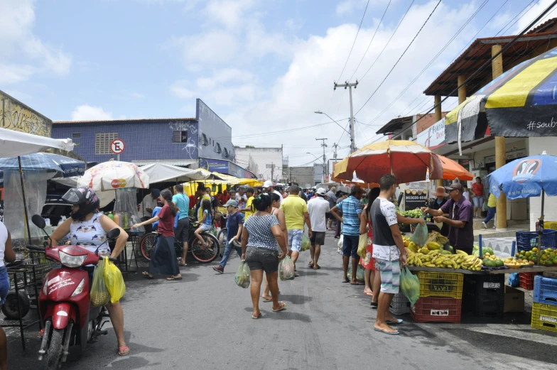 a group of people walk through an open market