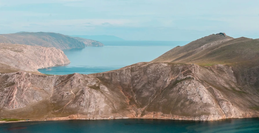 a hill by a lake with some water in the middle