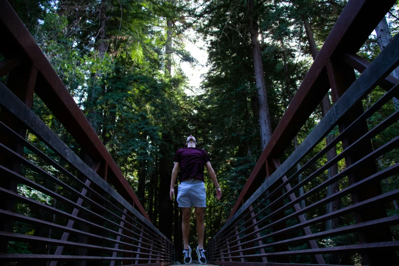 the man is walking across the bridge for his turn