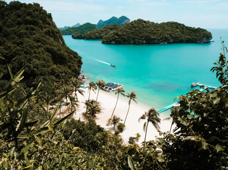 the water is blue and bright and there are many boats out on the sand