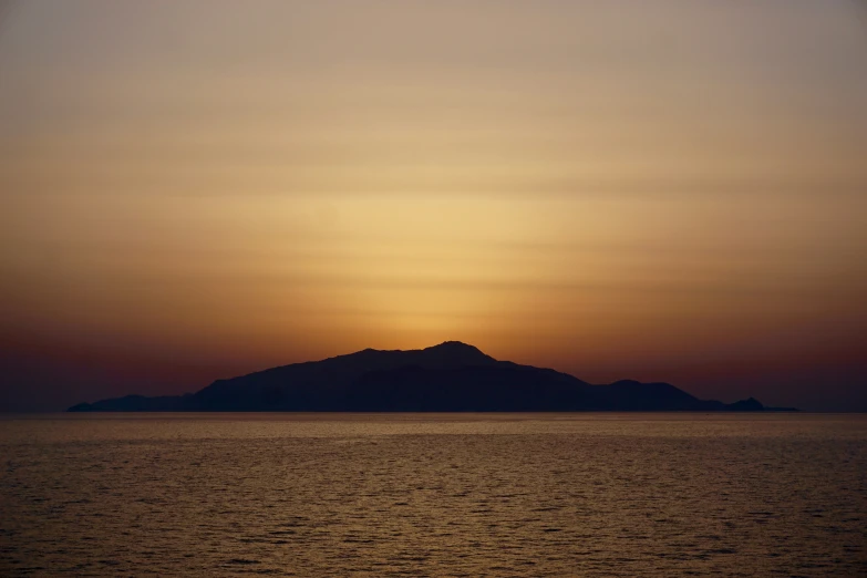 there is a boat at sea with the sunset in the background