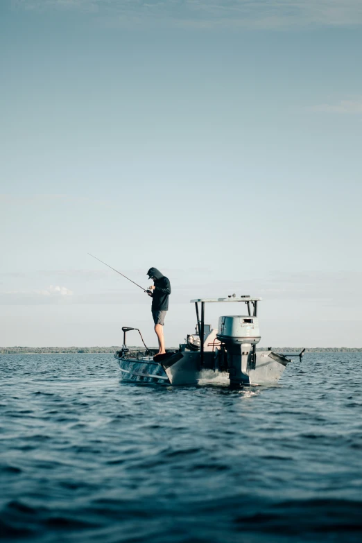 a man stands on the front of a fishing boat