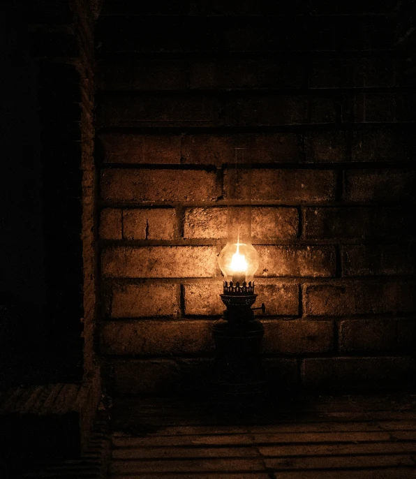 a lit candle sitting on top of a wooden bench