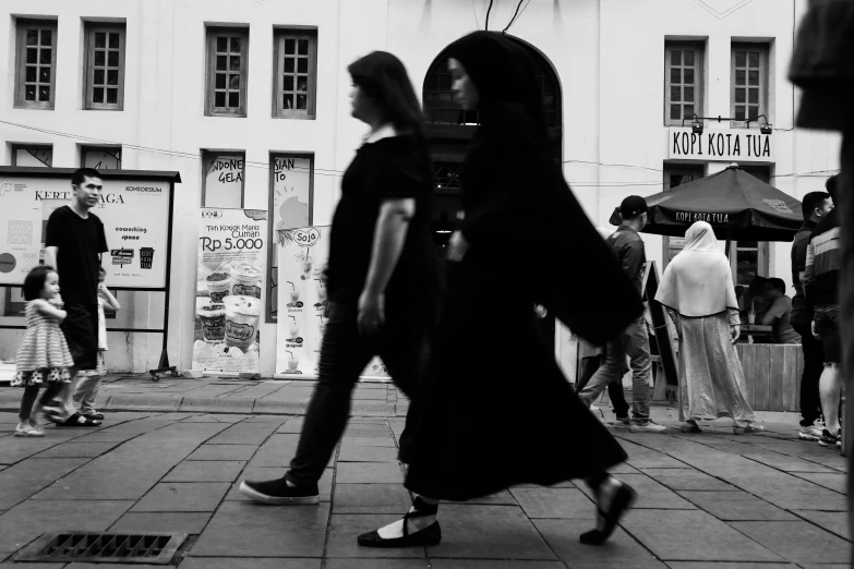 a girl walks down the sidewalk with an umbrella on her head