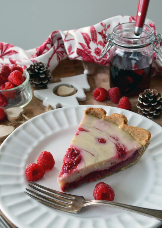 a piece of cheesecake is served on a plate with raspberries