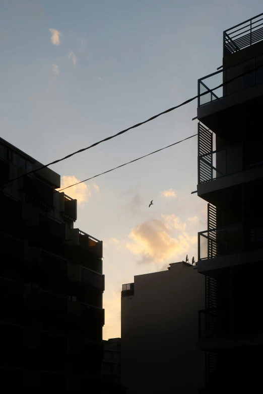 silhouette of apartment building with a jet airplane in the distance