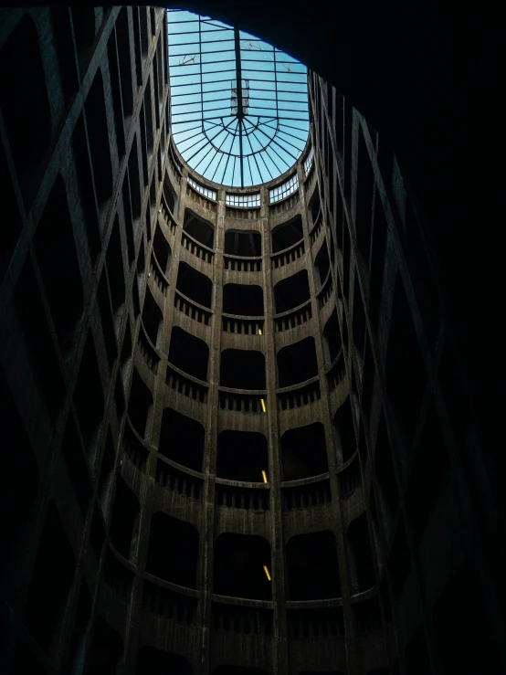 the interior of a very tall building, with a clock at the top