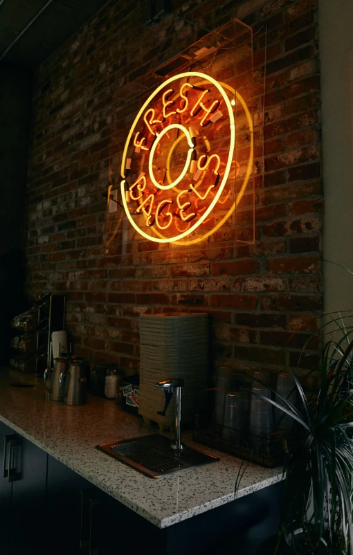 a neon sign above a counter with a computer on it