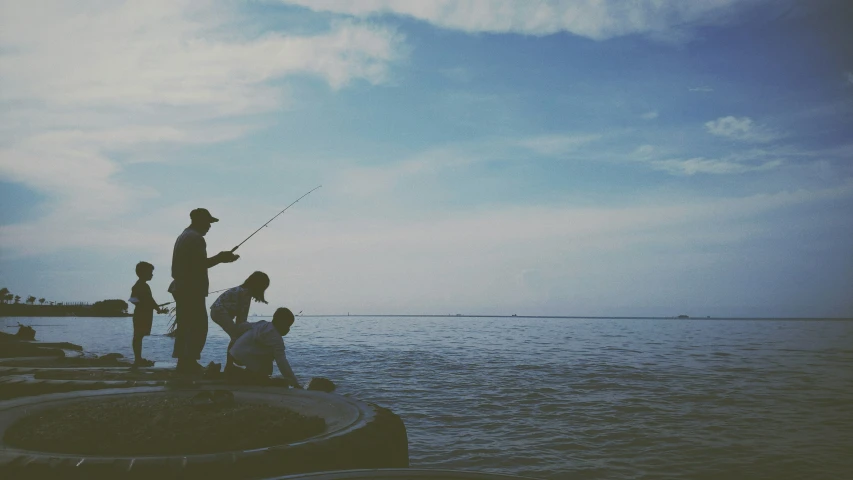 people standing on a dock flying kites in the sky