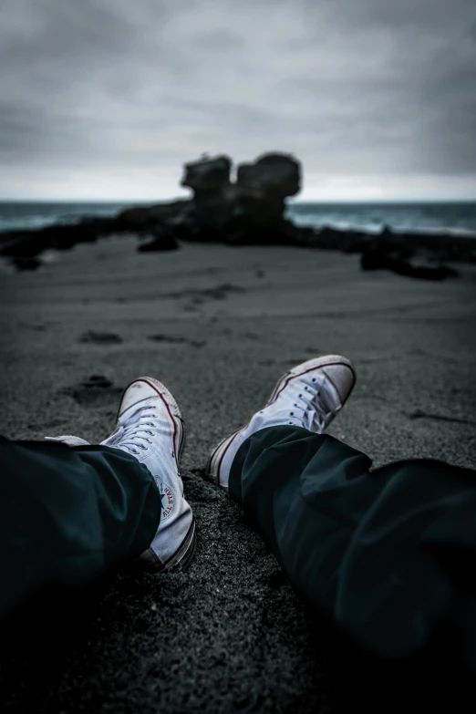 a person standing on a beach with shoes