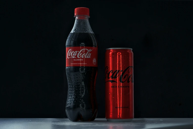 a coca - cola can with the coca - cola light logo on it and it is sitting beside a pepsi bottle