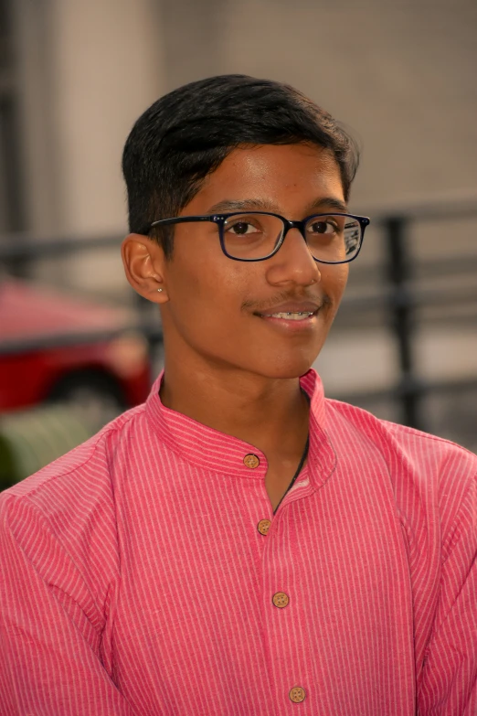 a man with glasses posing for a po