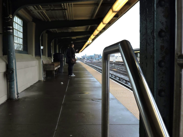 a train is leaving the platform where passengers are waiting