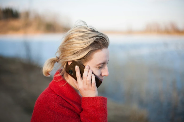 a blonde woman with ponytails on her head talking on a cell phone