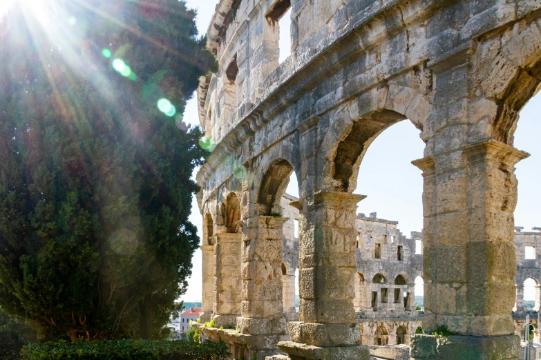 sunlight shines through the arches of the stone building