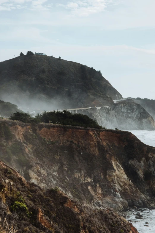 a train traveling along a hill near the ocean