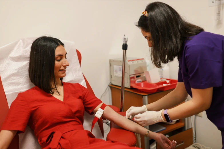 a lady holding up a hand as another person gives her soing