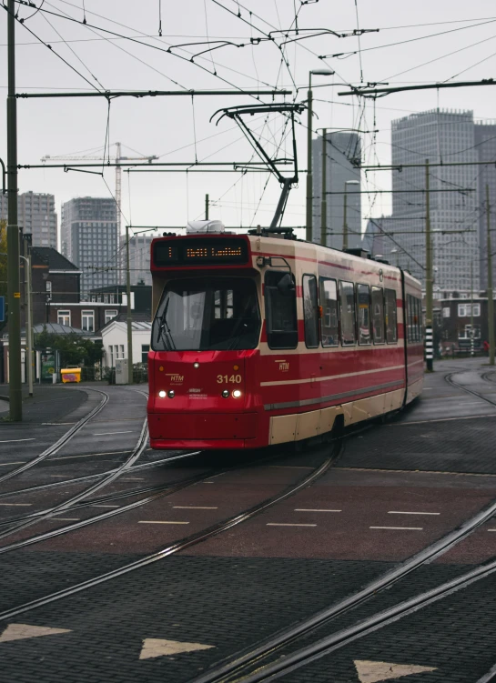 a red and white trolley car and city buildings