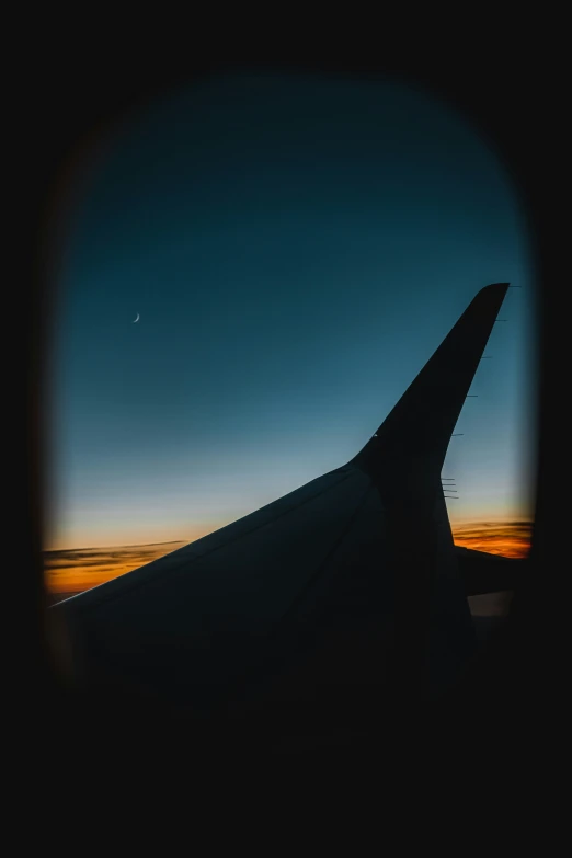 the view from an airplane window shows sunset and clouds