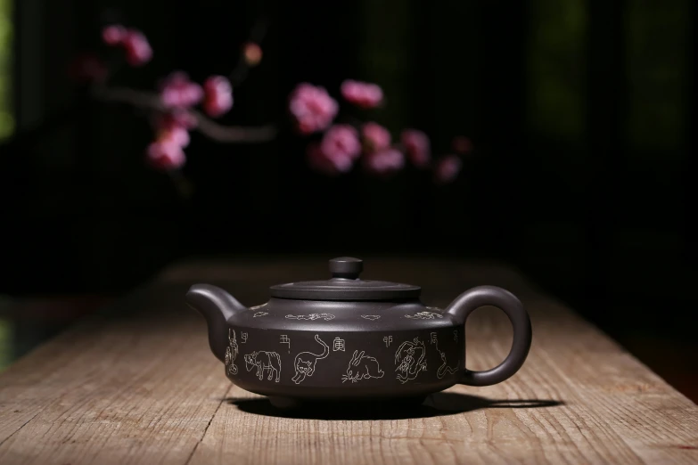 a teapot on a table with a tree in the background