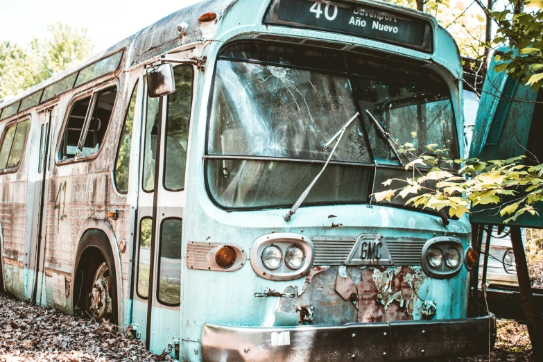 an old broken down bus with rusted paint on it