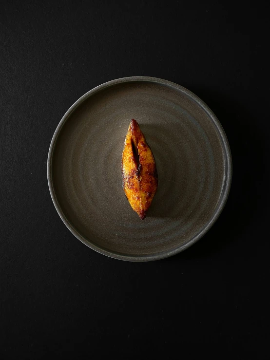 a plate with some food on it and black table