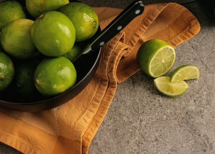 the bowl full of limes has two lime slices