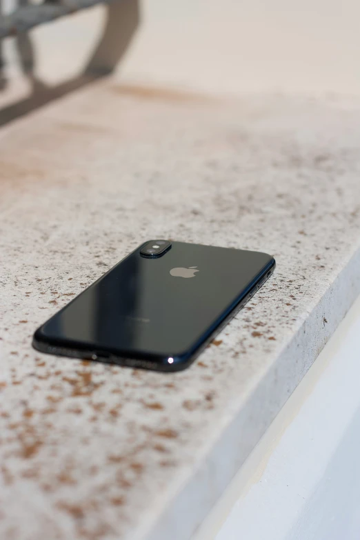 a closeup of a black iphone resting on a white surface