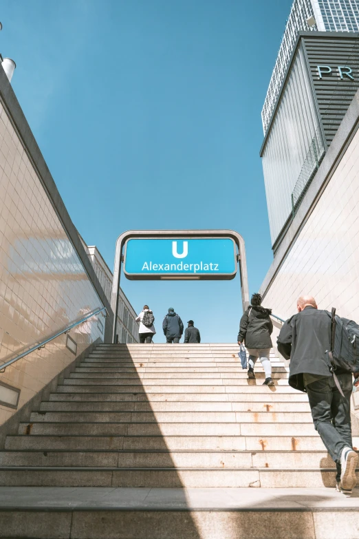 several people going up stairs on their way to a train station