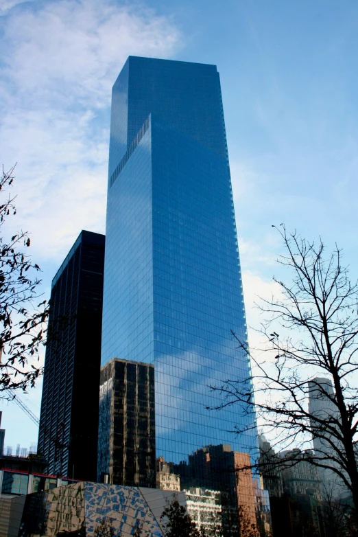 a large skyscr rises into the sky with other tall buildings in front of it