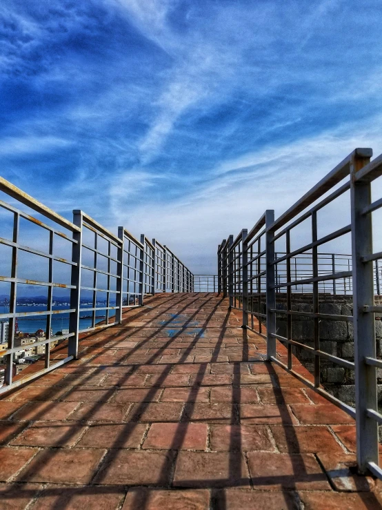 a brick paved road with two railings on the side