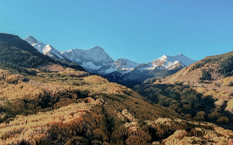 a scenic mountain range with trees and mountains in the distance