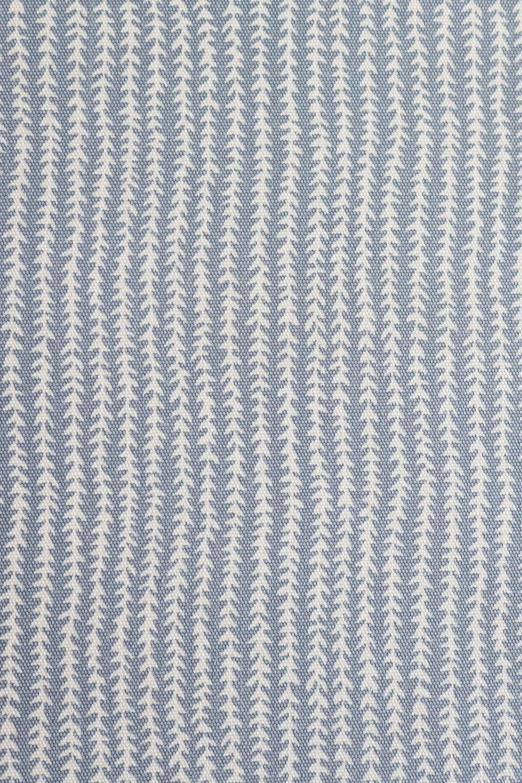 a light blue and white striped rug with waves in the middle
