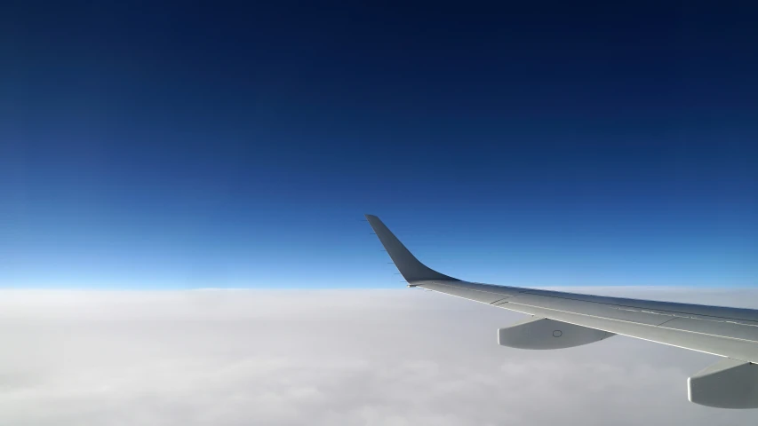 a view from inside a plane showing the wing and clouds
