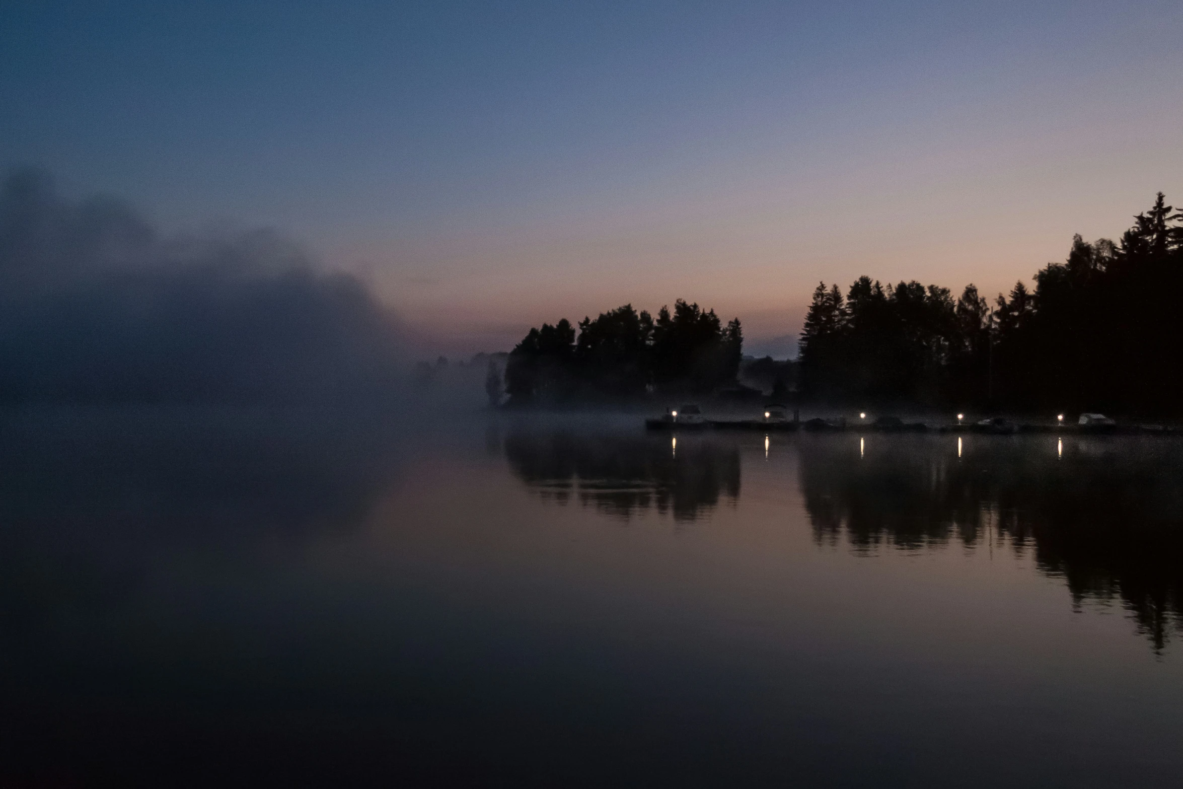 the mist is blowing in on a small lake