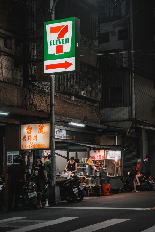 a man on a motorcycle parked by a street sign in a foreign city