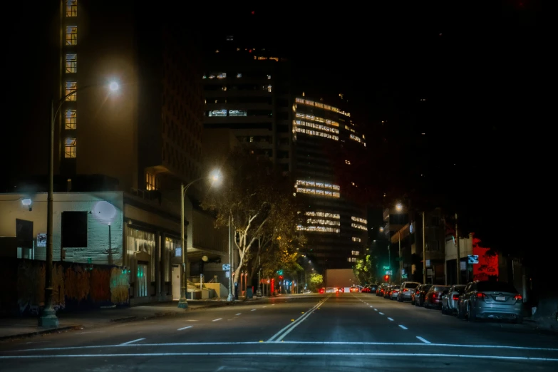 cars are parked on the street at night in the city