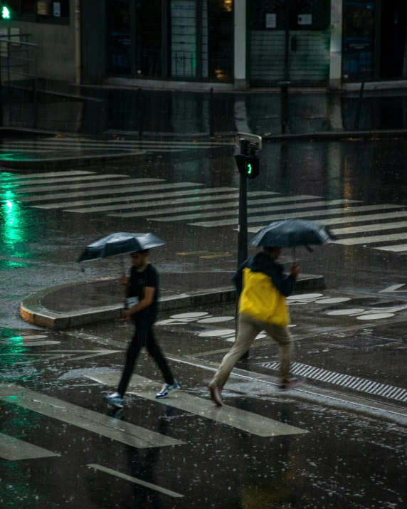 people crossing the street in the rain with umbrellas