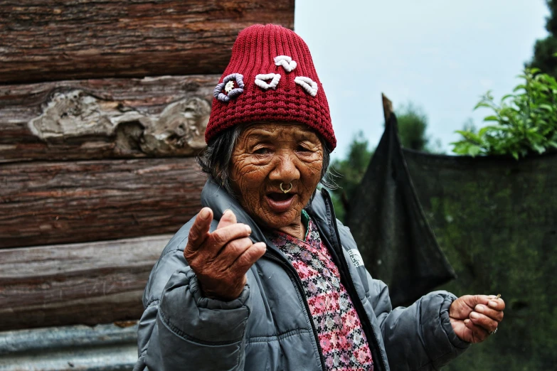 an elderly lady is pointing at someone on the cell phone